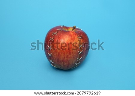             injured apple repaired on blue background                   