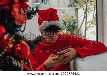 teenager with mobile phone at home at christmas