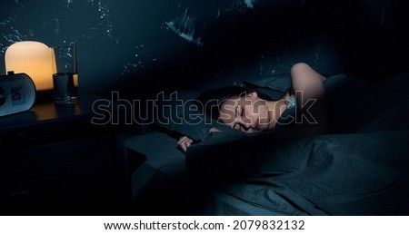 Beautiful young brunette woman sleeping on side, lying cozily in bed, hugging a pillow. Lady sound asleep at night. Loft interior. Royalty-Free Stock Photo #2079832132