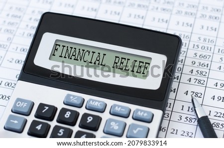 calculator with text financial relief on the screen rdom pen and reports, business concept