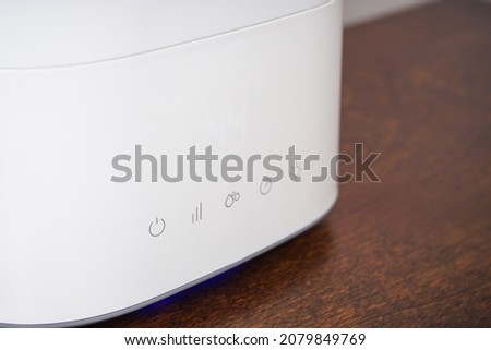 Modern humidifier on table against color background. Closeup.