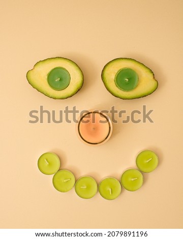 Christmas and Chinese new year snow man face made of candles and avocado, happy face smile nature concept.  Xmas decoration with copy space. Minimal colored.