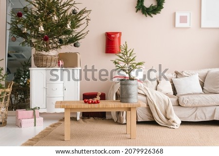 Christmas decor in the living room: sofa, Christmas tree, coffee table, gifts in delicate beige shades