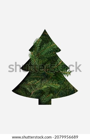 Creative Christmas tree shape made with cut paper and evergreen or pine branches on bright background. Flat lay.  Minimal table celebration New Year or Xmas concept.