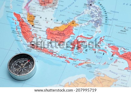 Compass on a map pointing at Indonesia and planning a travel destination Royalty-Free Stock Photo #207995719