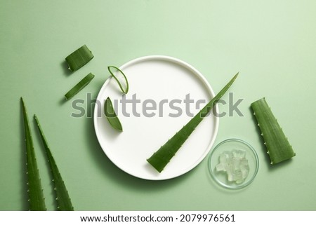Aloe vera extract research in laboratory with a petri dish and a white dish dropper in light green background for aloe vera research advertising , photography science content , top view
