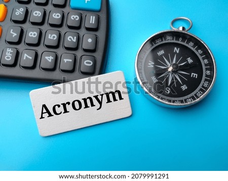 Calculator and compass with text Acronym on blue background.