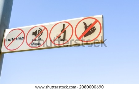 Banned activity sign showing activities not allowed against blue sky.