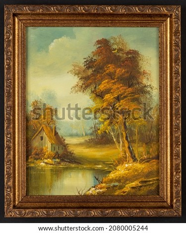 Framed vintage oil painting depicting a small cabin house near a lake and woods. Royalty-Free Stock Photo #2080005244