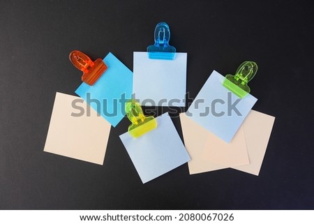 Post it notes in different colors with and without clips on dark background 