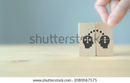 Knowledge and ideas sharing between two people head icon on wooden cube. Transferring knowledge, innovation, brainstorming concept. Business strategies to technology evolution re-skill and new skill.  Royalty-Free Stock Photo #2080067575