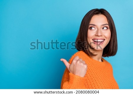 Profile side view portrait of attractive cheerful girl demonstrating copy space ad new isolated over bright blue color background Royalty-Free Stock Photo #2080080004