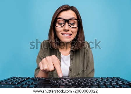 Photo of interested computer nerd lady try press button keyboard search web site camera isolated over blue color background