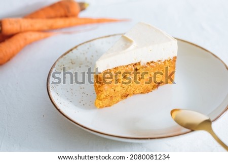 Carrot cake with cream cheese on top on a bright white backround