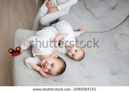 two little child brothers play together on the couch at home. place for text. copy space. family time at home. siblings
