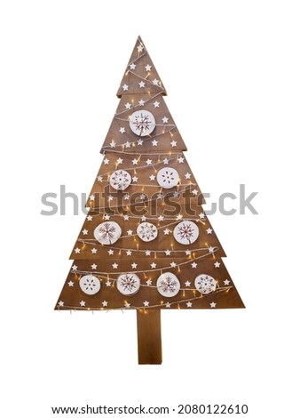 Wooden fir tree or spruce with christmas ornament or decorations and garland with warm yellow lights used as home decor on new year holidays isolated on white background