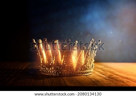 low key image of beautiful queenking crown over wooden table. vintage filtered. fantasy medieval period Royalty-Free Stock Photo #2080134130