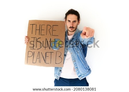 Stop climate change concept. Climate activist holding there is no planet b sign over white background points to camera