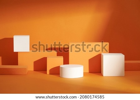 Front view of white and orange podium in a orange background for advertising , abstract content