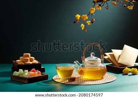 Chinese new year with red pocket teapot and biscuit jam in blue background for Tet holiday advertising , front view , holiday content