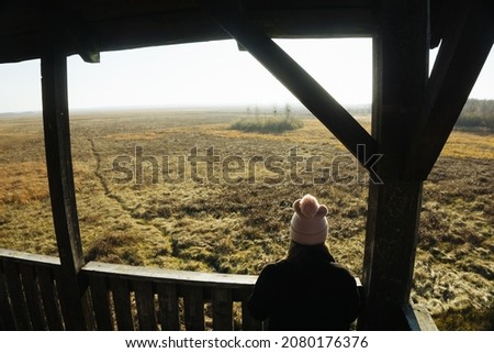 Grass swamp top view background. Girl watching the view. Autumn hunting stand view. National Park scenic view. Podlasie region in Poland. Biebrzanski National Park. Winter lifestyle travel landscape.