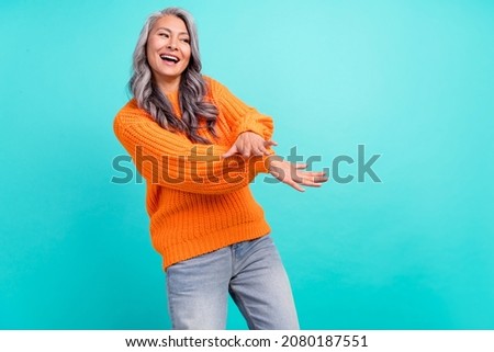 Photo of mature woman good mood discotheque clubber festive isolated over turquoise color background