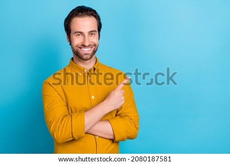 Photo of confident reliable promoter man indicate finger empty space wear yellow shirt isolated blue color background
