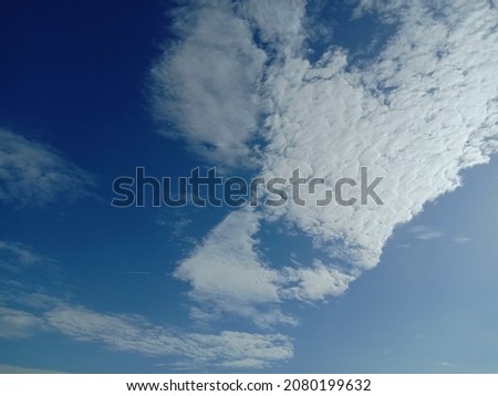 Blue sky with loose white clouds.