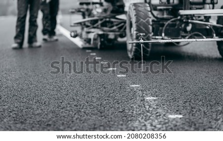 Workers applying new road markings, outside the city