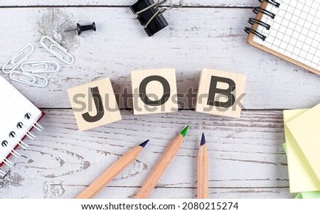 JOB text on wooden block with office tools on wooden background