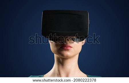 A young attractive woman in VR glasses. On a dark blue background