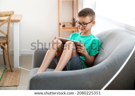 Cute boy watching cartoons at home