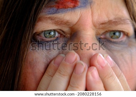 close-up of hand at female tear-stained face, beaten woman with bruises and abrasions, quiet cry for help, concept of domestic violence, emotion of suffering from pain, kidnapping, being in danger