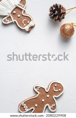Top view of decorated Christmas gingerbread cookies with decorations on white table background with copy space, concept of holiday celebration.