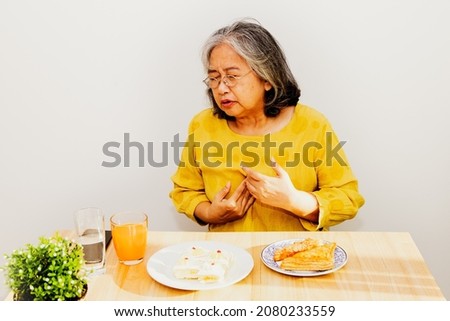 Elderly Asian women have acid reflux, throat tightness and chest tightness : Gastroesophageal reflux disease (GERD) Royalty-Free Stock Photo #2080233559