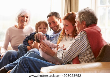 Multi Generation Family Sitting On Sofa With Newborn Baby Royalty-Free Stock Photo #208023952