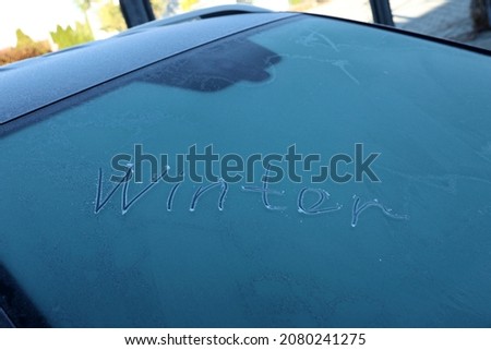 Winter - writing on a frozen car window.