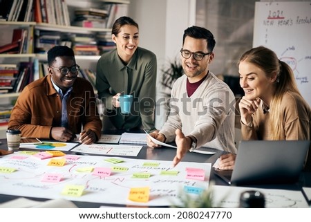 Group of young entrepreneurs analyzing mind map on paperboard while working on new business project at casual office.  Royalty-Free Stock Photo #2080247770