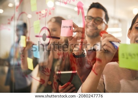 Close-up of entrepreneurs working on new business strategy and creating mind map on glass wall during the meeting.  Royalty-Free Stock Photo #2080247776