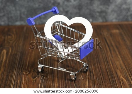 Shopping trolley with a white heart. Postcard or cover photo for shops, boutiques for valentine's day.