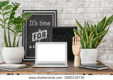 Interior of modern workplace   with wooden hand and laptop