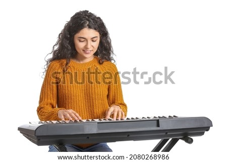 Young woman playing synthesizer on white background Royalty-Free Stock Photo #2080268986