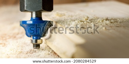 woodworking and carpentry. cutting the edge of the board with router. joinery background. copy space Royalty-Free Stock Photo #2080284529