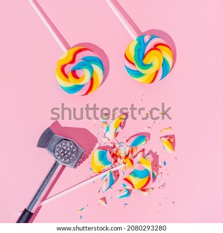 Lollipops on pastel pink background, top view. Broken with hammer candy. Sugar detox and junk food concept.