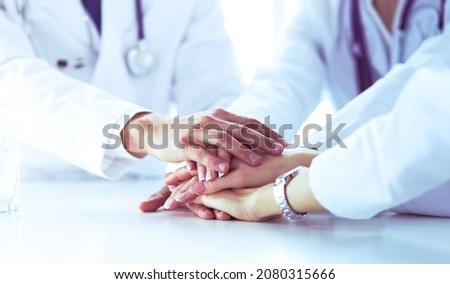 Team of doctors putting hands together, closeup