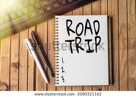 Sign displaying Road Trip. Internet Concept long distance journey on the road traveled by automobile Empty Open Clipped Journal Beside Keyboard Pens On Top Of The Wooden Desk.