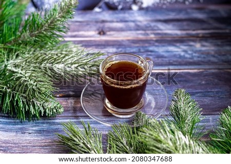 A cup of aromatic coffee with brown sugar, Christmas decorations, branches of a Christmas tree. Holiday concept New Year. On a wooden background. Copy space.