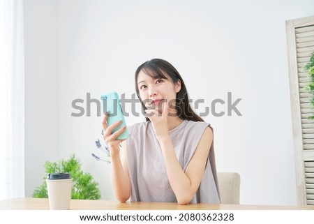 Asian woman using the smartphone at home
