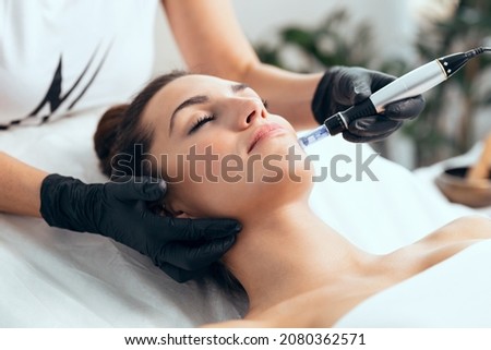 Shot of cosmetologist making mesotherapy injection with dermapen on face for rejuvenation on the spa center. Royalty-Free Stock Photo #2080362571