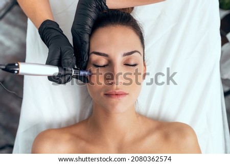 Shot of cosmetologist making mesotherapy injection with dermapen on face for rejuvenation on the spa center. Royalty-Free Stock Photo #2080362574